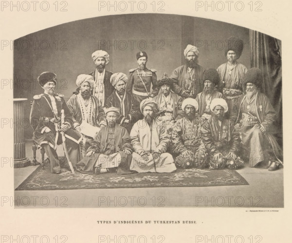 Group portrait of men from probably Uzbekistan, Types d'Indigènes du Turkestan Russe, page, photomechanical print, name: 'Silvestre et Cie, 97, rue Oberkampf.', printer (person): Silvestre et Cie, Paris, c. 1869 - in or before 1885, Silvestre et Cie, printer (person), paper, collotype, photoprint, height 127 mm x width 176 mm, human races, peoples, nationalities, A sepia-toned studio photograph showing a large group of men arranged in three rows, many wearing various styles of turbans, tall fur hats, and long robes, with several men wearing military-style jackets and belts; the front row is seated on a patterned rug with hands resting on their knees, the middle row sits on chairs, and the back row stands, all facing the camera with neutral expressions; a column is visible at the left edge and a draped curtain at the right, and the image has a rounded arch framing the top.