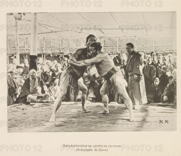 Représentant de lutteurs japonais, Sumo wrestling match in Tokyo, page, photomechanical print, inscription: 'HK', inscription: 'Photographie de l'autoriteit.', photographer: Hugues Krafft, Tokyo, cliché maker: anonymous, in or after 1882 - in or before 1884, Hugues Krafft, photographer, cliché maker, Kanto, paper, collotype, light printing, height 122 mm x width 172 mm, fighting contest (sport), wrestling (sport), Two shirtless men wearing traditional loincloths are grappling in a ring, their arms locked around each other and their bodies tensed; one man faces slightly toward the camera while the other looks past him. A crowd of spectators surrounds the ring, many seated and wearing robes, with varied facial expressions and postures; a man in darker clothing stands near the ring holding an object. The setting shows a covered structure with visible posts and a ceiling grid, and the ground inside the ring appears textured and worn.