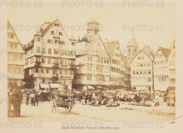 The Market Place, Stuttgard, View of a market in Stuttgart, photograph, page, photographer: Francis Frith, Stuttgart, c. 1855 - in or before 1865, Baden-Württemberg, paper, albumen print, height 120 mm x width 169 mm, market, A crowded outdoor marketplace scene with many people standing and walking on a wide open area in front of a row of multi-story, gabled buildings with numerous windows and balconies, a variety of roof shapes and small towers visible among them, market stalls and awnings along the ground level, stacks of goods and baskets on the ground, a horse-drawn cart facing the viewer near the center, people wearing period clothing including hats and long coats, and a tall tower rising behind the buildings.