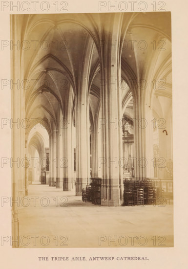 The triple aisle, Antwerp cathedral, photograph, page, Onze-Lieve-Vrouwekathedraal (Antwerp), c. 1856 - in or before 1866, photographer, Antwerp, paper, albumen print, height 160 mm x width 110 mm, interior of church, parts of church interior: aisle, A long interior view of a cathedral aisle with tall stone columns and pointed vaulted arches extending along the length, pale stone floors and walls, stacked wooden chairs arranged near the columns on one side, narrow clerestory windows letting in light, decorative stonework and an altar visible in the distance, and a printed caption centered below the image.