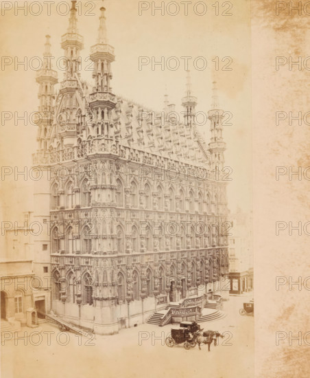 Hotel de ville, Louvain, photograph, page, c. 1856 - in or before 1866, photographer, paper, albumen print, height 173 mm x width 118 mm, townhall, façade (of house or building), Stadhuis (Leuven), A large ornate Gothic building with multiple tiers of pointed arches, decorative tracery, and tall spires dominates the left and center of the image, showing rows of sculpted niches and intricate stonework along its facade and roofline; steps and a balustraded entrance lead up to the building, and a street scene in front includes horse-drawn carriages and a few small street structures, with adjacent simpler buildings visible at the edges and a pale, textured backdrop filling the right side of the image.