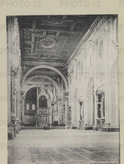 St. John Lateran's church, page, photomechanical print, photographer: Samuel J. Beckett, Sint-Jan Lateran, printmaker: Samuel J. Beckett (possibly), c. 1890 - c. 1900, Samuel J. Beckett, photographer, printmaker, Rome, Sint-Jan van Lateranen, paper, collotype, photoprint, height 203 mm x width 152 mm, interior of church, parts of church interior: aisle, A large interior space with a high decorated ceiling featuring carved panels and a central circular medallion, a series of tall arched openings along a wall with sculpted figures in niches, ornate columns and pilasters, an elevated altar or ornamental structure with pointed decorative gables and an organ-like facade beneath a vaulted arch, patterned floor tiles in the foreground, and carved decorative mouldings and reliefs along the upper walls.