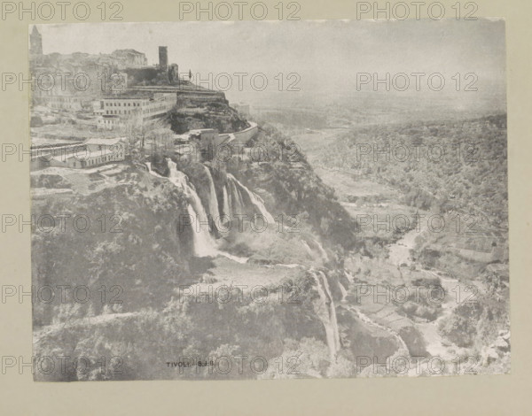 Tivoli, page, photomechanical print, photographer: Samuel J. Beckett, c. 1890 - c. 1900, paper, collotype, photoprint, height 153 mm x width 202 mm, city-view in general, 'veduta', waterfall, A grayscale photograph showing a cliffside town with clustered buildings and a prominent tower near the top, terraced slopes and a winding road along the cliff edge, cascading waterfalls flowing down rock faces into a river below, scattered trees and vegetation across the hillside and valley, cultivated plots and pathways visible in the lower landscape, and a hazy distant plain extending toward the horizon.