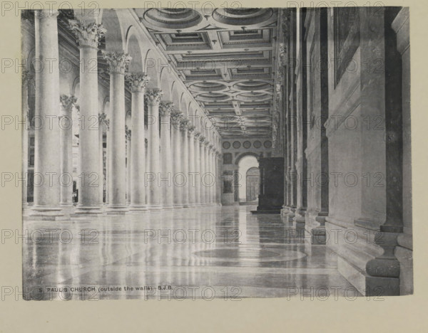 S. Paul's church (outside the walls), page, photomechanical print, photographer: Samuel J. Beckett, Saint Paul's Outside the Walls, printmaker: Samuel J. Beckett (possibly), c. 1890 - c. 1900, photographer, Rome, Saint Paul outside the Walls, paper, collotype, photoprint, height 147 mm x width 198 mm, interior of church, parts of church interior: aisle, A long colonnade with tall smooth columns topped by ornate capitals lines a highly polished reflective floor, a patterned coffered ceiling runs above with circular and rectangular recessed panels, a series of arches connects the columns on one side while a solid wall with pilasters and molded bases runs along the opposite side, light and shadow create reflections on the floor, and an archway and doorway are visible at the far end.
