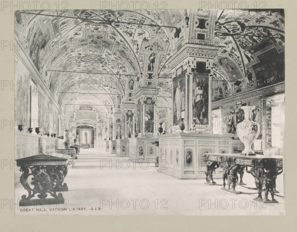 Great hall, Vatican library, page, photomechanical print, photographer: Samuel J. Beckett, Biblioteca Apostolica Vaticana, c. 1890 - c. 1900, Vatican City, paper, collotype, photoprint, height 151 mm x width 197 mm, interior, representation of a building, public library, A long ornate gallery with a vaulted, heavily painted ceiling and decorated arches, lined on both sides by paneled display cabinets and tall pilasters with large framed paintings; ornate wooden tables with carved legs and decorative vases sit along the floor, and sculpted corbels and reliefs appear on the furniture and architectural elements; windows and doorways punctuate the side walls, and the perspective shows the corridor receding toward a distant doorway.