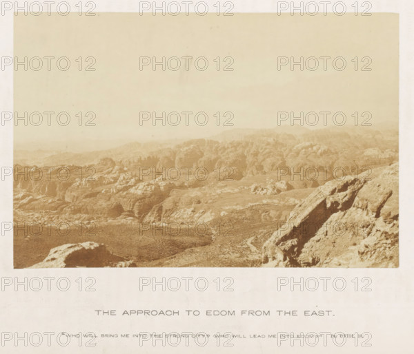 View of a landscape with mountains, referred to as Edom, The approach to Edom from the east, photograph, page, inscription: ''Who will bring me into the strong city? Who will lead me into Edom?' Ps. CVIII.10.', photographer: Francis Frith (possibly), c. 1850 - c. 1865, paper, albumen print, albumendruk, height 105 mm x width 157 mm, mountains, A sepia-toned photograph of a rocky, desert-like landscape with eroded rock formations and rugged hills extending toward a hazy horizon, with a foreground of large weathered boulders and a sloping rocky ridge on the right, and a wide pale sky occupying the upper portion of the image.