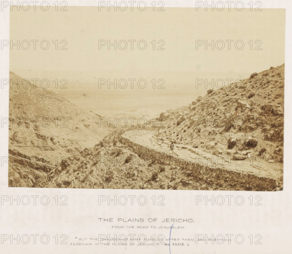 The plains of Jericho. From the road to Jerusalem, Landscape near Jericho, photograph, page, inscription: ''But the Chaldeans' army followed after them, and overtook Zedekiah in the plains of Jericho.' Jer XXXiX. 5.', photographer: Francis Frith (possibly), Jericho, c. 1850 - c. 1865, Francis Frith, photographer, Palestine, West Bank, paper, albumen print, height 104 mm x width 157 mm, mountains, desert - KK - ideal landscapes, A sepia-toned landscape photograph shows a rocky, arid terrain with steep hillsides and scattered low vegetation, a winding stone wall or terrace cutting across the slope toward the foreground, a narrow dirt path running alongside the wall, and two small human figures standing on the path; the background fades into a hazy plain and distant horizon under a pale sky.