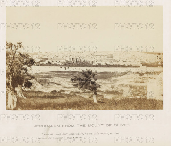 Jerusalem from the Mount of Olives, photograph, page, inscription: ''And he came out, and went, as he was wont, to the Mount of Olives.' Luke XXII. 39.', photographer: Francis Frith (possibly), Jerusalem, c. 1850 - c. 1865, paper, albumen print, height 103 mm x width 155 mm, landscapes, city-view in general, 'veduta', A sepia-toned panoramic view shows a walled cityscape in the distance with a large domed building rising above clustered low structures, rows of trees and open courtyards visible inside the walls, a stretch of open terrain with pathways and scattered vegetation in the foreground, and twisted tree trunks and leafy branches framing the left and center foreground against a pale sky.