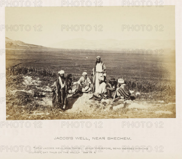 View of a landscape with seven men, referred to as Jacob's Well, Jacob's Well, Near Shechem, photograph, page, inscription: ''Now Jacob's well was there, Jesus therefore, being worn with his journey, sat thus on the well.'John IV. 6.', photographer: Francis Frith (possibly), c. 1850 - c. 1865, Francis Frith, photographer, paper, albumen print, height 103 mm x width 155 mm, landscapes, A sepia-toned photograph shows a wide open grassy plain with low rolling hills in the distant background and a group of men gathered on the foreground ground near a light-colored patch of earth; the men wear layered long robes and headwraps in varying tones and some sit while others stand, with one taller figure standing near the center; the scene includes rough vegetation, scattered stones, and a pottery vessel on the ground near the seated figures, all within a faded bordered photographic print.