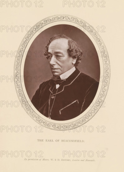 The Earl of Beaconsfield, page, photomechanical print, photographer: Downey, William & Daniel, London, c. 1869 - in or before 1881-04-19, printmaker, paper, Woodburytype, height 116 mm x width 93 mm, Person, Benjamin Disraeli, politician, eg party leader, An oval-framed sepia portrait of an older man shown from the chest up wearing a dark coat with a high white collar and a bow at the neck, his hair curly at the sides and receding at the top, a small pointed beard on his chin, a thoughtful expression with downcast eyes, set against a plain darker oval background and surrounded by an ornate border on a light paper page.