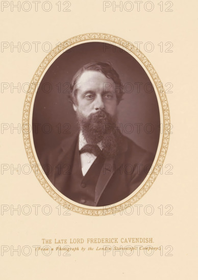 The late lord Frederick Cavendish, page, photomechanical print, photographer: London Stereoscopic Company, London, c. 1875 - c. 1880, printmaker, paper, Woodburytype, height 110 mm x width 87 mm, Person, Frederick Cavendish, politician, eg party leader, An oval sepia portrait of a man with wavy hair and a full beard set against a dark background, framed by an ornate patterned border on a light beige page; the man wears a dark jacket, vest, and a white shirt with a bow tie, and his gaze is directed slightly off center.