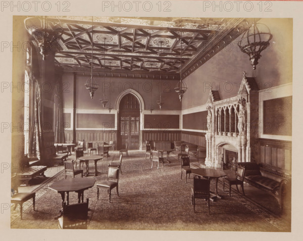 Reception Room in Manchester City Hall, photograph, page, title: 'The Reception-Room', photographer: J. McLeod, Manchester City Hall, 1877, Manchester, paper, albumen print, height 162 mm x width 214 mm, town hall, interior, representation of a building, A large ornate room with an intricately patterned coffered ceiling and multiple hanging spherical chandeliers, wood-paneled walls with tall rectangular panels, a central arched doorway with glass panes, numerous wooden tables and chairs scattered across a patterned carpet, tall draped windows along the left wall, cushioned benches and armchairs along the sides, and an ornate carved stone fireplace with decorative columns and statues on the right wall.