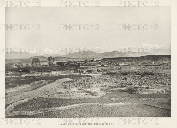 View of Maru Khel, Khyber Pakhtunkhwa, Pakistan, page, photomechanical print, caption: 'MARUKHEL VILLAGE AND THE SAFED KÓH', photographer: Frederick Saint John Gore, Maru Khel, c. 1890 - in or before 1895, printmaker, paper, collotype, photoprint, height 120 mm x width 178 mm, city-view in general, 'veduta', mountain-range, snow peaks, A wide landscape photograph showing a foreground of rough, rocky ground with visible furrows and a winding dirt path, leading back to a middle ground of low, flat agricultural terraces and scattered trees, a small cluster of low buildings and structures set against gently rolling hills, and a distant range of higher mountains with snow-capped peaks under a broad, pale sky.