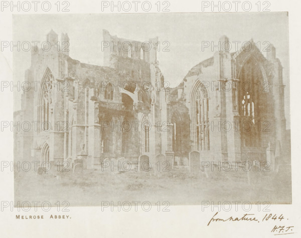 Melrose Abbey, reproduction, page, photomechanical print, inscription: 'from nature 1844. HFT', after photo by William Henry Fox Talbot, Scotland, c. 1889 - in or before 1899, William Henry Fox Talbot, photographer, printmaker, paper, autotype, height 102 mm x width 147 mm, ruin of church, monastery, Melrose (Scotland), A faded photographic image of a large stone ruin with tall arched windows and partially collapsed walls, showing Gothic architectural details and vertical columns, set within a grassy foreground scattered with upright stone markers and low vegetation, the sky above appearing pale and uniform.