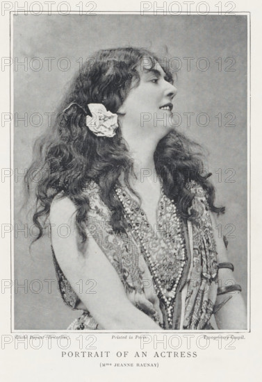 Portrait of an actress, page, photomechanical print, photographer: Louis Désiré Dupont, Brussels, printmaker: Goupil & Cie., c. 1889 - in or before 1899, paper, autotypie, typogravure, height 133 mm x width 98 mm, Person, Jeanne Raunay, portrait of actor, actress, A black and white portrait of a woman shown from the waist up in profile facing right, with long wavy hair cascading over her shoulders and a large flower tucked behind one ear, wearing a patterned sleeveless garment and multiple layered necklaces, her head tilted slightly back and her lips parted in a slight smile, framed by a rectangular border and a light textured backdrop.