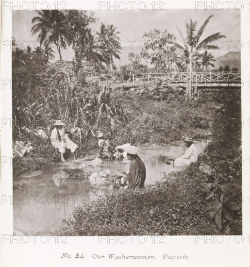 Our Washerwomen. Papeete, Women washing clothes in a river near Papeete, page, photomechanical print, number: 'No. 24.', photographer: Henry Stuart-Wortley, Papeete, cliché maker: Meisenbach's Autotype Company, printer (person): Meisenbach's Autotype Company, 1880, Meisenbach's Autotype Company, photographer, French Polynesia, Tahiti, paper, collotype, photoprint, height 134 mm x width 135 mm, trees: palm-tree, building or outbuilding where laundry is done, A sepia photograph showing a riverside scene with several people sitting at the water's edge washing cloths, surrounded by dense tropical vegetation including tall palm trees and broad-leaf plants, a wooden bridge crossing the stream in the background, reflections of foliage and figures visible in the water, and garments and bundles placed on the riverbank.