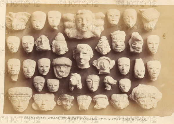 Terra cotta heads, from the pyramids of San Juan Teotihuacan, photograph, page, Mexico, c. 1870 - in or before 1880, photographer, North America, paper, albumen print, height 102 mm x width 155 mm, sculpture, head (human), A grid of small sculpted heads arranged against a rectangular backdrop, each head carved from a light-colored material with varied facial features and headgear, showing smooth and textured surfaces, some with rounded faces, some elongated, some partial or worn, and a few with pronounced brows, noses, or lips; the backdrop has a warm sepia tone and a narrow border around the edges, with a strip of paper visible below the backdrop.