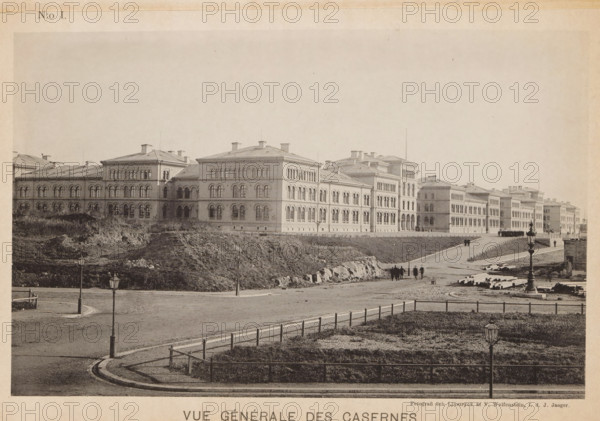 View of a barracks of the Svea livgarde at the Linnégatan in Stockholm, Vue générale des casernes, page, photomechanical print, number: 'N:o I.', maker: V. Wolfenstein, Stockholm, maker: Johannes Jaeger, c. 1888 - in or before 1891, paper, collotype, photoprint, height 120 mm x width 189 mm, barracks, A wide photographic view of a long multi-story stone building with rows of arched windows and a pitched roof stretching across the middle ground, set behind a gently sloping grassy embankment and a paved roadway; in the foreground a curved curb and fenced grassy area are visible with lamp posts lining the street, and small groups of people are walking along the road toward the buildings; scattered construction materials and rough ground appear near the embankment and the farther end of the road.