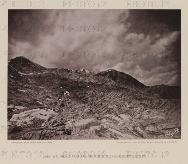 View of the Wildkarspitze, Das Wildkar vor losbrüch eines Scheesturmes, page, photomechanical print, number: 'IX.', photographer: Friedrich Simony, Austria, cliché maker: Friedrich Bruckmann, Vienna, publisher: Eduard Hölzel, c. 1879 - in or before 1889, Lower Austria, paper, collotype, photoprint, height 143 mm x width 190 mm, mountain-top, peak, Tirol, Wildkarspitze, A monochrome photograph shows a rocky mountain landscape with craggy ridges and patches of snow scattered across rough textured slopes, the foreground featuring fractured rocks and a prominent ice formation, and the upper portion dominated by a cloudy sky with varying tonal clouds above the mountain peaks.