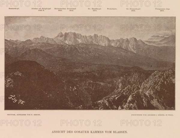 Ansicht des Gosauer Kammes vom Blassen, View of the Gosaukamm, page, photomechanical print, number: 'XIX.', photographer: Friedrich Simony, Salzburg (city), cliché maker: Angerer & Göschl, C., Vienna, publisher: Eduard Hölzel, 1876, Lower Austria, paper, autotypie, height 120 mm x width 217 mm, city-view in general, 'veduta', Dachstein (Salzburg), Gosaukamm, A sepia-toned panoramic image of a mountain range with jagged peaks rising in the background above rolling, rocky foothills and forested slopes, framed by a dark foreground of rugged rock formations and cliffs, with a pale sky occupying the upper area.
