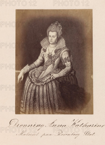 Photo reproduction of a painting depicting a portrait of Queen Anna Catherine of Brandenburg, Dronning Anna Katharine, photograph, reproduction, page, inscription: 'Maleriet paa Rosenborg Slot', photographer: Julius Wulff, after painting by Pieter Isaacsz., c. 1858 - in or before 1862, paper, albumen print, albumendruk, height 166 mm x width 122 mm, Person, Anna Catharina van Brandenburg, ruler, sovereign - BB - female ruler, A monochrome portrait of a woman seated and facing forward, wearing an ornate period gown with a high lace ruff around her neck and a fitted bodice decorated with ribbons and floral embellishments, her hair styled high with decorative ornaments, a string of pearls at her neckline and a pendant, one hand resting on the arm of a chair and the other holding part of her skirt, the skirt patterned with vertical designs and layered fabric, a large feathered accessory at her side, all set against a dark background with a light border around the image.