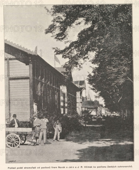 Pohled podél stromoradi od pavilonú firem Novák a Jahn a JR Vilimek ku pavilonu ceských cukrovarnikú, Pavilion on the Výstavište in Prague, page, photomechanical print, Výstavište, cliché maker: Carl Bellmann, Prague, c. 1891 - in or before 1893, photographer, paper, autotypie, height 206 mm x width 167 mm, temporary exhibition, 'Salon', façade (of house or building), A street scene shows a long wooden building with a covered walkway and decorative roof edge on the left, shaded by large leafy trees that extend across the upper right area of the image, with tree trunks and dense foliage forming a canopy over the right side. Several people stand in front of the building near a wooden cart with a large spoked wheel, some dressed in suits and hats, and a child is among them. Further down the street, additional buildings with varied rooflines and small architectural details are visible between gaps in the trees, and dappled light and shadow fall across the roadway.