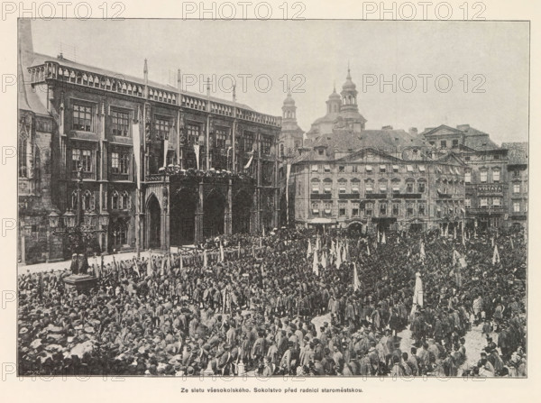 Crowd at the Staromestské námestí in Prague during a festival of the Sokol movement, Ze sletu vsesokolského. Sokolstvo pred radnici staromestskou, page, photomechanical print, Staromestské námestí, cliché maker: Carl Bellmann, Prague, c. 1891 - in or before 1893, photographer, paper, autotypie, height 187 mm x width 262 mm, public festivities, village square, Place, A large crowd fills a historic city square in front of ornate multi-story stone buildings with arched openings and decorative façades, many people holding upright banners and clustered closely together, a raised balcony area on one building crowded with people, several spired towers and domed roof structures visible behind the row of buildings, and a street lamp with ornate metalwork visible near the left side of the image.