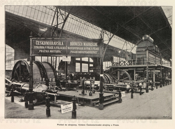 Interior of an engine room with an exhibition of Czech-Moravian machines, Pohled do strojovny. Výstava Ceskomoravské strojirny v Praze, page, photomechanical print, Prague, clichémaker: Carl Bellmann, c. 1890 - in or before 1895, photographer, paper, autotype, height 176 mm x width 258 mm, interior, representation of a building, machines, parts of machines, tools and appliances, A large indoor industrial hall with a high arched glass and metal roof, metal support columns, and a raised platform along one side; the floor area is filled with heavy machinery including large cylindrical drums, flywheels, pistons, pipes, and other mechanical components mounted on bases and connected by belts and rods; a prominent double-sided framed board hangs from a support near the center, and another framed board is mounted on the raised platform; railings and stair access are visible on the platform, along with a large rounded metal tank or boiler on the platform; scattered signs hang above some machine...
