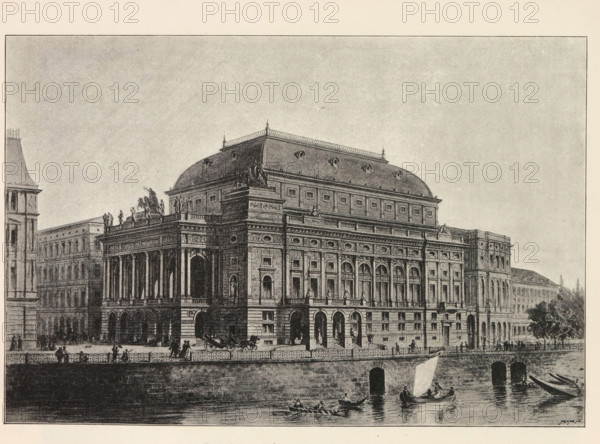 Perspektivni pohled na Národni divadlo v Praze, Photo reproduction of a drawing depicting an exterior of the National Theater in Prague, reproduction, page, photomechanical print, Prague, cliché maker: Carl Bellmann, after drawing by anonymous, c. 1891 - in or before 1895, photographer, paper, autotypie, height 180 mm x width 263 mm, façade (of house or building), theater (building), National Theater, A detailed monochrome illustration of a large ornate building with a tall mansard roof and decorative balustrades, featuring a grand façade with columns, arched openings on the ground level, rows of rectangular windows, sculptural figures along the roofline and at corners, and intricate stonework and friezes; the building sits beside a riverside embankment with a stone wall and arched openings at water level, small boats and rowboats on the water with figures aboard, horse-drawn carriages and pedestrians on the promenade, and distant trees and adjacent multi-story buildings extending alon...