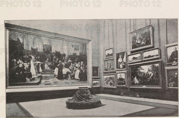 Photo reproduction of a painting depicting the celebration of Corpus Christi in Bohemia, Václav Sochor, reproduction, page, photomechanical print, Prague, cliché maker: Carl Bellmann, c. 1891 - in or before 1895, photographer, paper, autotypie, height 141 mm x width 120 mm, feast of Corpus Christi, A large gallery room with framed paintings covering the walls, including one very large historical scene on the left showing figures in robes and architectural arches, and a cluster of variously sized framed portraits and landscapes on the right arranged in a grid; a low upholstered stool draped with patterned fabric sits on the floor in the foreground, and the floor shows bordered carpeting leading toward the walls.