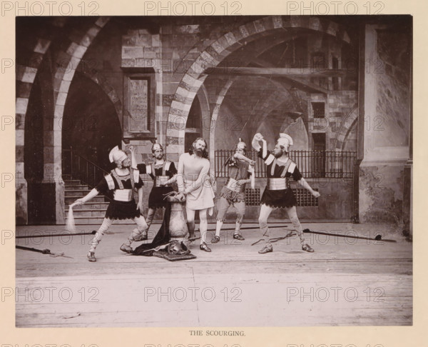 The scourging, page, photomechanical print, inscription: 'Gemeinde Oberammergau Passionsspiel 1890', photographer: Carl Stockmann, Oberammergau, cliché maker: anonymous, c. 1885 - in or before 1890, Bavaria, paper, collotype, photoprint, height 180 mm x width 230 mm, group of actors, troupe, actors on the stage, flagellation by soldiers, Christ usually tied to a column (Matthew 27:26, Mark 15:15, John 19:1), A group of five men in historical costumes stand on a wooden floor in front of a stone arcade with rounded arches and a staircase. Four men wear helmets, decorative chest plates, short tunics, and sandals, and two of them hold whips with motion visible. The central figure stands barefoot with bare legs and arms, wearing a simple draped cloth around his waist and a rope tied around his wrists, his head tilted and hair hanging to his shoulders. A large draped cloth lies on the floor near a carved stone column beside the central figure. The background shows masonry with alternating li...