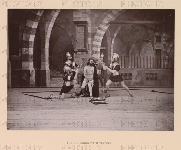 The crowning with thorns, page, photomechanical print, inscription: 'Gemeinde Oberammergau Passionsspiel 1890', photographer: Carl Stockmann, Oberammergau, cliché maker: anonymous, c. 1885 - in or before 1890, Bavaria, paper, collotype, photoprint, height 167 mm x width 227 mm, group of actors, troupe, actors on the stage, the crowning with thorns: soldiers with sticks place a thorny crown on Christ's head and give him a reed (Matthew 27:27-31, Mark 15:16-20, John 19:2-3), A staged scene set against a stone arcade with striped arches and a stairway shows a seated man with bare torso and draped cloak surrounded by four armored figures wearing helmets and tunics; two of the armored figures are kneeling while the others stand, and they hold a circular object above the seated man's head and ropes or cords around his arms, with additional props including a helmet on the floor and a cushion nearby, all on a wooden floor in front of a railing and masonry backdrop.