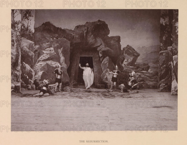The resurrection, page, photomechanical print, inscription: 'Gemeinde Oberammergau Passionsspiel 1890', photographer: Carl Stockmann, Oberammergau, cliché maker: anonymous, c. 1885 - in or before 1890, Bavaria, paper, collotype, photoprint, height 168 mm x width 228 mm, group of actors, troupe, actors on the stage, Resurrection of Christ, A staged scene set against a painted rocky backdrop with a central dark cave entrance, a robed figure standing in the cave entrance with one arm raised, four armored figures around the cave wearing helmets and tunics with greaves, two of the armored figures kneeling and two standing, scattered rocks and low vegetation at the cave mouth, a wide wooden floor in the foreground, and tall painted rock formations and trees framing the scene on both sides.