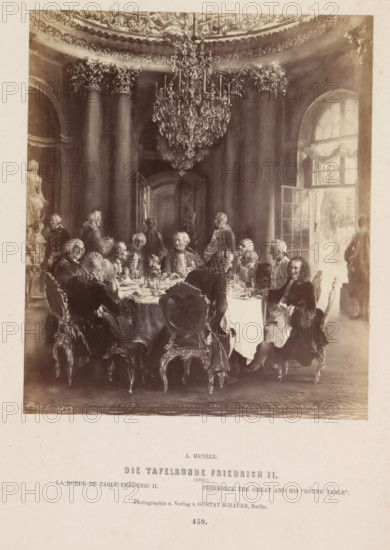 The Round Table of Frederick II, Photographic reproduction of a painting of Frederick the Great at the table in Sanssouci Palace by Adolf Menzel, photograph, reproduction, page, number: '459.', photographer: Gustav Schauer, Berlin, after painting by Adolph Menzel, c. 1858 - in or before 1868, paper, albumen print, height 165 mm x width 140 mm, Person, Frederick II (King of Prussia), evening meal, dinner, supper, table-ware, Potsdam, Sanssouci, A sepia-toned scene of a formal dining room with a large round table covered by a cloth and set with dishes and glassware, surrounded by men in period clothing with powdered wigs seated on ornate chairs; a large crystal chandelier hangs from a decorated ceiling above, fluted columns rise behind the group, a tall arched window with drapery admits light on one side, a doorway stands open in the background, a marble statue is visible near one edge, and a standing figure is near the window.