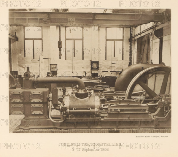 Anniversary Exhibition. 9-17 September 1893, Anniversary exhibition with a steam boiler for the 25th anniversary of the machine factory of Gebroeders Stork & Co, page, photomechanical print, number: 'No. 16.', Hengelo (Overijssel), maker: Emrik & Binger, Haarlem, c. 1893-09-09 - in or before 1893-09-17, photographer, paper, collotype, photogravure, height 165 mm x width 216 mm, factory-interior, machine shop, exhibition, show, A sepia-toned industrial interior showing large mechanical equipment and heavy machinery arranged across the floor, including a prominent flywheel with spokes on the right, large cylindrical housings and pipes in the foreground, rectangular casings with bolted access panels on the left, and various rods, linkages, and valves connecting components; the background wall features tall arched windows with panes and a brick surface, chains and hooks hanging from an overhead girder that spans the room, and a framed decorative circular object mounted on the wall among sh...