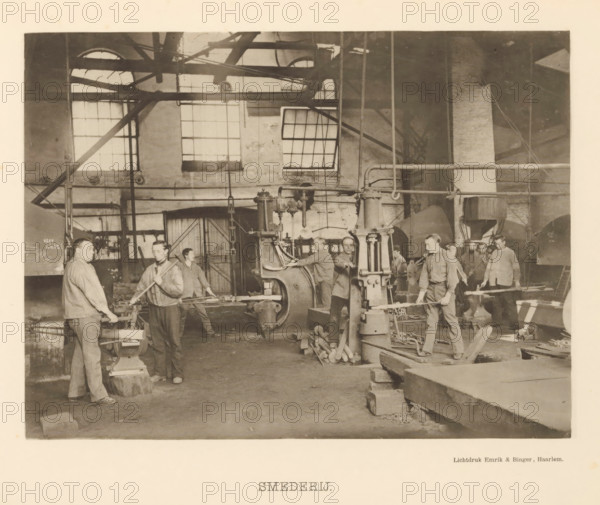 Forge, Interior with workers of the forge of the machine factory of Gebroeders Stork & Co, page, photomechanical print, number: 'No. 7.', Hengelo (Overijssel), maker: Emrik & Binger, Haarlem, c. 1884 - in or before 1894, photographer, paper, collotype, light print, height 158 mm x width 212 mm, factory-building, factory-interior, machine shop, A sepia-toned indoor scene shows a large workshop with tall windows and visible beams and pipes across the ceiling and walls; several men wearing work shirts and trousers stand among heavy machinery and tools, some holding long metal rods and others positioned by large mechanical presses and anvils; piles of metal pieces, chains, and wooden blocks lie on the floor, and a door and various metal frameworks occupy the background, while light filters in through the multi-paned windows.