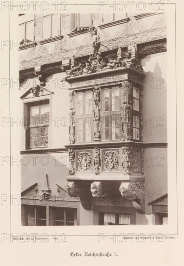 Bay window of a building at Reichenstraße 3 in Braunschweig, Erker Reichenstraße 3, Braunschweig's Baudenkmäler, page, photomechanical print, number: 'No. 17.', photographer: J. Schombardt, Braunschweig, cliché maker: Römmler & Jonas, Dresden, publisher: Benno und Wilhelm Danert Goeritz, 1892, J. Schombardt, Römmler & Jonas, Benno und Wilhelm Danert Goeritz, photographer, cliché maker, publisher, Lower Saxony, Saxony, paper, collotype, photoprint, height 151 mm x width 99 mm, facade (of house or building), bay window, oriel, A close view of a building facade showing an ornate bay window projection with carved decorative panels and sculpted supports, multiple paneled windows within the bay framed by detailed vertical carvings, an ornamented cornice above the bay topped with a small sculpted figure holding a staff, adjacent plain window openings set into the wall, and additional carved architectural details and bracketed elements beneath the bay casting a shadow on the wall.