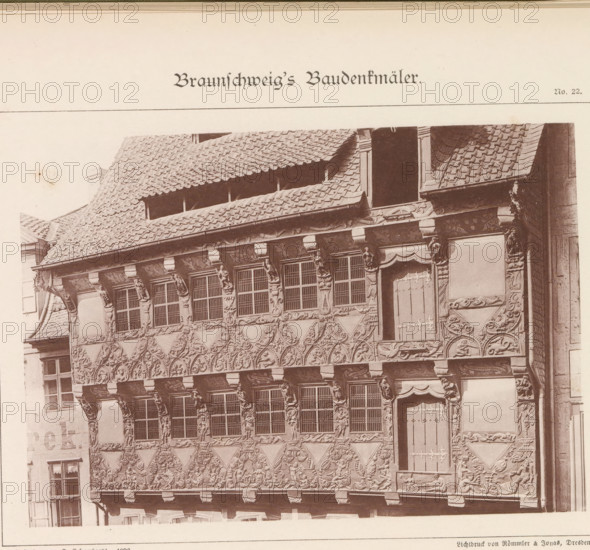 Haus Sack No 5, Facade of the house at Sack 5 in Braunschweig, Braunschweig's Baudenkmäler, page, photomechanical print, number: 'No. 22.', photographer: J. Schombardt, Braunschweig, cliché maker: Römmler & Jonas, Dresden, publisher: Benno und Wilhelm Danert Goeritz, 1892, J. Schombardt, Römmler & Jonas, Benno und Wilhelm Danert Goeritz, photographer, cliché maker, publisher, Lower Saxony, Saxony, paper, collotype, photoprint, height 111 mm x width 155 mm, housing, facade (of house or building), A sepia-toned photograph shows the upper facade of an ornate timber-framed building with a steep tiled roof and decorative carved wooden panels. The facade features rows of rectangular windows with small panes, each set within sculpted surrounds and supported by carved figures and brackets. Between and below the windows are intricately carved geometric and figurative reliefs forming repeating triangular patterns and ornamental borders. A tall, narrow door with visible hinges is set into the fac...