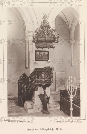 Pulpit of the Riddagshausen Abbey in Braunschweig, Kanzel der Riddagshäuser Kirche, Braunschweig's Baudenkmäler, page, photomechanical print, number: 'No. 34.', photographer: J. Schombardt, Riddagshausen Abbey, cliché maker: Römmler & Jonas, Dresden, publisher: Benno und Wilhelm Danert Goeritz, Braunschweig, 1892, J. Schombardt, Römmler & Jonas, Benno und Wilhelm Danert Goeritz, photographer, cliché maker, publisher, Lower Saxony, Saxony, paper, collotype, photoprint, height 158 mm x width 106 mm, pulpit, ambo, chancel, abbey, monastery, convent, Roman Catholic church, An interior scene showing a carved wooden pulpit with ornate reliefs and statues, elevated on a stone base with a staircase leading up, a tall decorative canopy with sculpted figures suspended above it, a standing carved figure holding a staff positioned at the base, a framed painting mounted on the wall behind the pulpit, tall arched stone columns and vaulting in the background, a multi-branched candelabrum in the foreg...