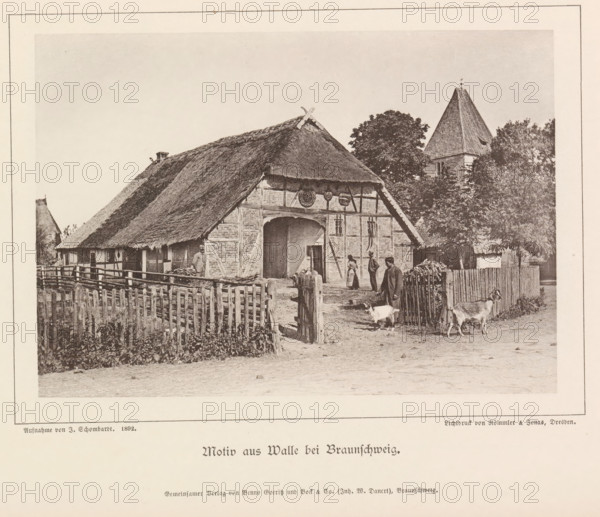 Motiv from Walle bei Braunschweig, Exterior of a farm in Walle, Braunschweig's Baudenkmäler, page, photomechanical print, number: 'No. 39.', photographer: J. Schombardt, Walle, cliché maker: Römmler & Jonas, Dresden, publisher: Benno und Wilhelm Danert Goeritz, Braunschweig, 1892, J. Schombardt, Römmler & Jonas, Benno und Wilhelm Danert Goeritz, photographer, cliché maker, publisher, Lower Saxony, Saxony, paper, collotype, photoprint, height 105 mm x width 151 mm, farm (building), facade (or house or building), A sepia-toned photograph of a rural scene showing a thatched-roof farmhouse with exposed timber framing and a large arched entrance, a wooden picket fence in front, a few people standing near the entrance and along the yard, two goats in the foreground near the gate, stacks of firewood beside the fence, leafy trees behind and to the side of the house, and a steep-roofed tower partially visible among the trees.
