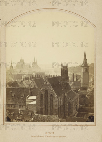 View of Erfurt, seen from the Johannesturm, Erfurt (vom Johannes Kirchthurm aus gesehen), photograph, page, number: '4', Johanneskirche, c. 1858 - in or before 1868, photographer, Thuringia, paper, albumen print, height 128 mm x width 102 mm, Image opposite page 40., city-view in general, 'veduta', A sepia-toned view of a cityscape framed by an arched border, showing a cluster of stone buildings with pitched roofs in the foreground, a large Gothic church with tall arched windows and a tower with ornate pinnacles, a square clock tower with a tall spire to the right, rows of smaller houses and rooftops extending into the distance, distant church spires and cathedral silhouettes softened by haze, and a narrow strip of decorative border and paper surrounding the image.