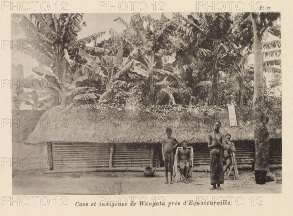 Four residents of Wangata in front of a wooden house, Case et indigènes de Wangata près d'Equateurville, page, photomechanical print, number: 'Pl. 27.', photographer: Franz Thonner, Wangata, cliché maker: Stengel & Markert, Dresden, 1896, Franz Thonner, Stengel & Markert, photographer, cliché maker, Saxony, paper, collotype, photoprint, height 109 mm x width 161 mm, family group, especially parents with their child(ren), housing, façade (of house or building), A horizontal black-and-white photograph showing a thatched-roof structure with a wall made of horizontal slats, partially obscured by a tall grass roof edge; behind and above the roof are dense tall plants with large broad leaves and trunks. In front of the building stand four people with bare torsos; two are positioned in simple wooden chairs with high backs, one stands directly beside a seated person, and another stands holding a long narrow object vertically. On the ground near them are a rounded pot and a dark woven basket, a...