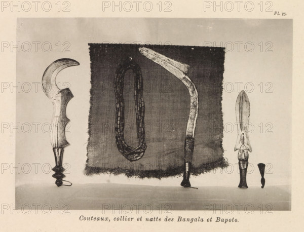 Couteaux, collier et wet des Bangala et Bapoto, Knives, necklace and a mat of the Bangala and Bapoto, page, photomechanical print, number: 'Pl. 35.', photographer: Franz Thonner, Congo (country), cliché maker: Stengel & Markert, Dresden, 1896, Saxony, paper, collotype, light printing, height 110 mm x width 158 mm, tools, aids, implements, crafts and industries: knife, necklace, door furniture, eg boot scraper, brush, doormat, A rectangular piece of woven cloth with frayed edges is centered against a plain background, with a looped necklace of bead-like segments hanging down its middle; to the right of the cloth a curved implement with a decorated handle and a blade that narrows then flares is positioned vertically, its handle wrapped near the base, and to the far right a spear-like object with a double-edged blade sits above a carved handle; to the left of the cloth a crescent-shaped blade with a carved handle and an ornate lower grip is visible.