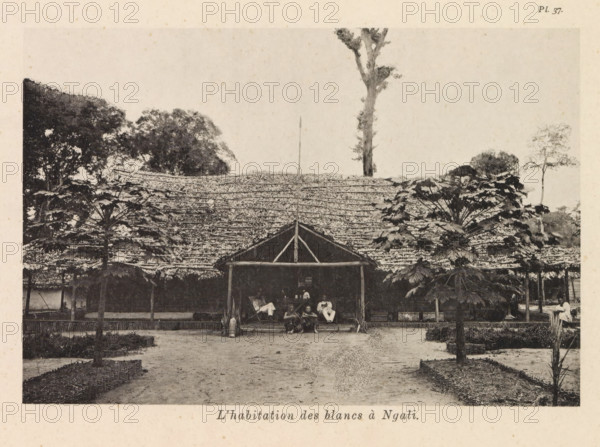 L'habitation des blancs à Ngali, Exterior of a house in Ngali, page, photomechanical print, number: 'Pl. 37.', photographer: Franz Thonner, Ngali, cliché maker: Stengel & Markert, Dresden, 1896, Franz Thonner, Stengel & Markert, photographer, cliché maker, Saxony, paper, collotype, photoprint, height 110 mm x width 162 mm, housing, façade (of house or building), A wide thatched structure with a triangular front gable and a central pole stands behind a cleared yard, flanked by tall leafy trees with broad leaves and smaller vegetation; the thatch shows layered texture and a tall slender tree rises behind it; in front of the building an open porch area contains several seated people and a few objects, and low woven fences form raised planting beds at the yard edges, with a dirt ground extending toward the foreground.