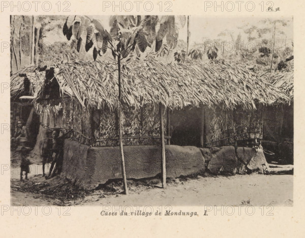 Exterior of a dwelling in a village of the Mondunga, Cases du village de Mondunga I, page, photomechanical print, number: 'Pl. 38.', photographer: Franz Thonner, Congo (country), cliché maker: Stengel & Markert, Dresden, 1896, Saxony, paper, collotype, photogravure, height 108 mm x width 160 mm, housing, façade (of house or building), A thatched-roof structure with layered palm or grass leaves covering the roof sits in the center of the image, supported by slender vertical poles and surrounded by woven wall panels and textured fabric wraps; a young tree with broad leaves stands in front of the roof, partially obscuring it, while foliage and taller trees form a background; to the left, several partially visible people stand or sit near the building, with one child closer to the foreground; the ground in front of the structure appears sandy with scattered debris and a low raised base around the building.