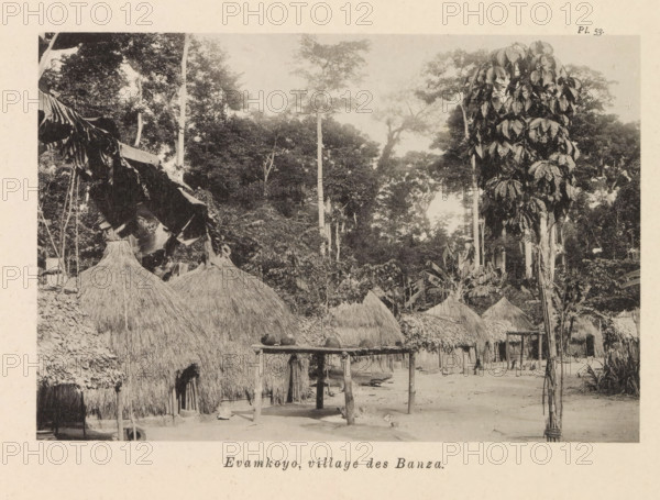 Houses in Evamkoyo, Evamkoyo, village des Banza, page, photomechanical print, number: 'Pl. 53.', photographer: Franz Thonner, Congo (country), cliché maker: Stengel & Markert, Dresden, 1896, Saxony, paper, collotype, light printing, height 110 mm x width 161 mm, housing, façade (of house or building), A sepia-toned scene shows a cluster of thatched huts with conical roofs made of straw, arranged on bare ground beneath tall trees with dense foliage. In the foreground there is a wooden rack on stilts with several rounded objects placed on top, and a narrow clearing between the huts. Large leafy plants and tall slender tree trunks rise behind and among the huts, and broad leaves hang from a torn canopy on the left edge of the image. The overall setting appears shaded by the surrounding trees and vegetation.