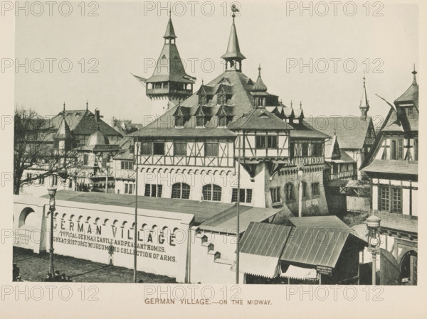 German Village.- on the Midway, View of a recreated German village at the World's Columbian Exposition in Chicago in 1893, page, photomechanical print, number: 'Plate 100', photographer: Charles Dudley Arnold, Chicago, photographer: HD Higinbotham, cliché maker: anonymous, 1893, Charles Dudley Arnold, HD Higinbotham, photographer, cliché maker, North America, Illinois, paper, collotype, photoprint, height 133 mm x width 191 mm, world fair, world exhibition, World's Columbian Exposition, A panoramic view of timber-framed buildings with steep, multi-gabled roofs and ornamental spires, featuring dormer windows and decorative half-timber patterns on upper walls, a tall tower with a covered balcony and a pointed roof rising above the central structure, arched openings and rectangular windows on lower levels, a foreground wall with an arcade and a lamppost casting a shadow on the lawn, awnings over entrances, bare tree branches visible at the left edge, and a skyline of varied rooflines and ...