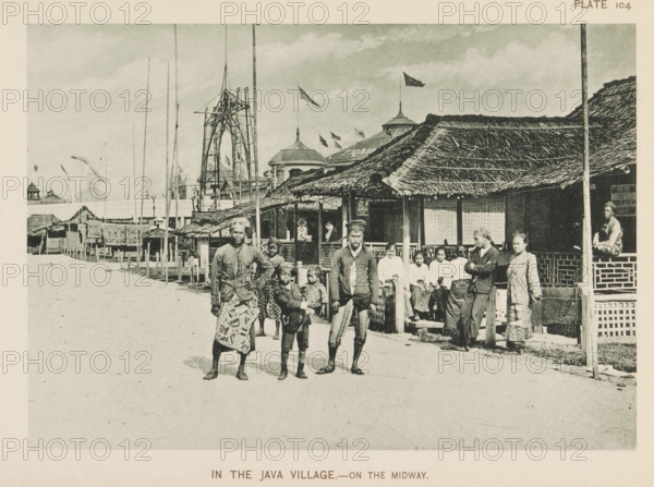 Houses and people from Java at the World's Columbian Exposition in Chicago in 1893, In the Java village.- on the Midway, page, photomechanical print, number: 'Plate 104', photographer: Charles Dudley Arnold, Chicago, photographer: HD Higinbotham, cliché maker: anonymous, 1893, Charles Dudley Arnold, HD Higinbotham, photographer, cliché maker, North America, Illinois, paper, collotype, photoprint, height 133 mm x width 190 mm, world fair, world exhibition, World's Columbian Exposition, A wide street scene shows a row of thatched-roof buildings with woven walls and open fronts along one side, with tall poles and flagpoles rising behind them and a pavilion-like structure with domed roofs visible further back; a group of people stands and sits near the buildings, including adults and children wearing patterned cloth wraps and shirts, some barefoot and some leaning on railings, while one person is seated on a raised platform; in the foreground a few figures walk toward the camera on a broad...