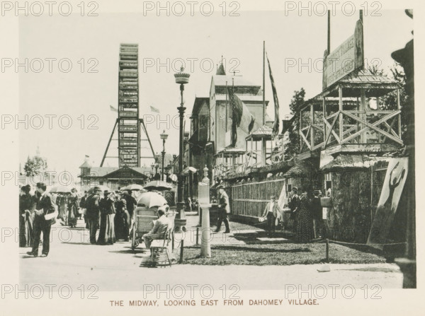View of a street with national pavilions and a Ferris wheel at the World's Columbian Exposition in Chicago in 1893, The Midway, looking east from Dahomey village, page, photomechanical print, number: 'Plate 107', photographer: Charles Dudley Arnold, Chicago, photographer: HD Higinbotham, clichémaker: anonymous, 1893, Charles Dudley Arnold, HD Higinbotham, photographer, clichémaker, North America, Illinois, paper, collotype, photogravure, height 134 mm x width 190 mm, world fair, world exhibition, giant wheel, Ferris wheel, World's Columbian Exposition, A crowded outdoor scene with many people walking and standing along a wide pathway, several holding umbrellas and wearing hats and early twentieth-century clothing, a person seated on a bench beside a baby carriage, a tall Ferris wheel structure visible in the background near ornamental lamp posts, a row of buildings and wooden viewing platforms with railings and flags flying from poles, trees behind the structures, and a freestanding ca...