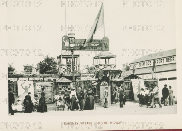 Replica of a Dahomey village at the World's Columbian Exposition in Chicago in 1893, Dahomey village, on the Midway, page, photomechanical print, number: 'Plate 110', photographer: Charles Dudley Arnold, Chicago, photographer: HD Higinbotham, cliché maker: anonymous, 1893, Charles Dudley Arnold, HD Higinbotham, photographer, cliché maker, North America, Illinois, paper, collotype, photoprint, height 132 mm x width 191 mm, world fair, world exhibition, World's Columbian Exposition, A crowded outdoor scene shows a wooden entrance structure with two raised watchtower-like platforms, a tall lamppost in front, and a large flag flying above one side; beneath the raised platforms are shaded booths with awnings and a sign hanging centrally; a group of people in period clothing stand and walk in the foreground, including women in long dresses and hats, men in suits and hats, and some seated figures and a person in a small wheeled chair; wooden fencing and painted display panels flank the entran...